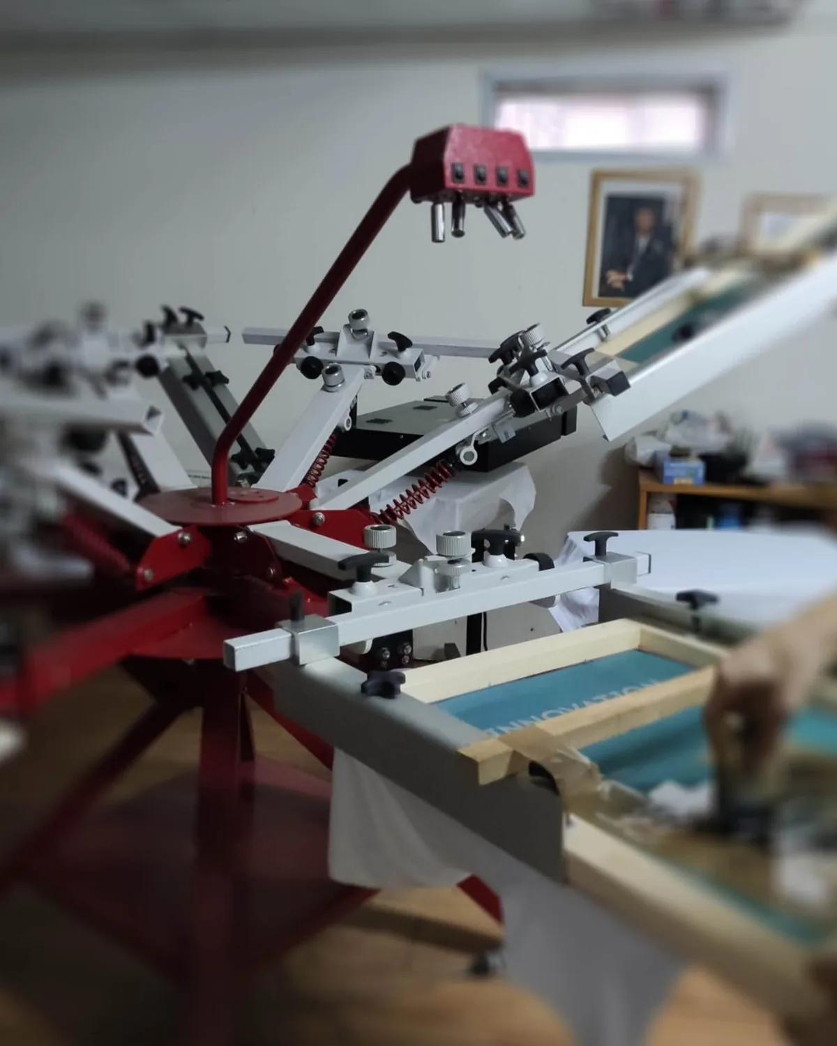 Macchina serigrafica a giostra in funzione nel laboratorio stArt76
